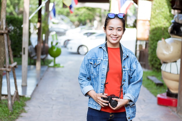 Turisti asiatici della ragazza che trasportano le macchine fotografiche