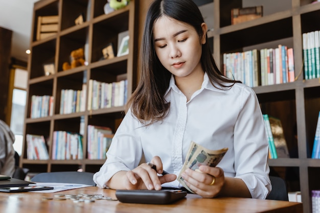 Asian girl using calculator for personal accounting