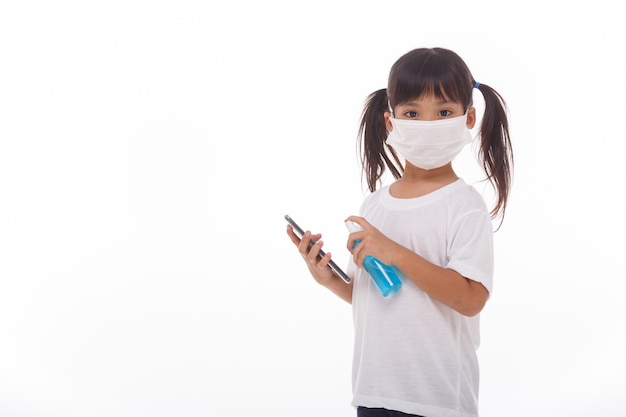 Asian girl wear mask cleaning smartphone screen with alcohol