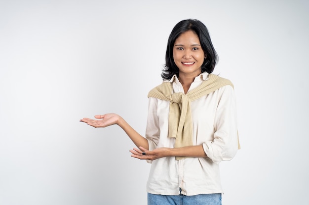 Photo asian girl with hand gesture presenting something on isolated