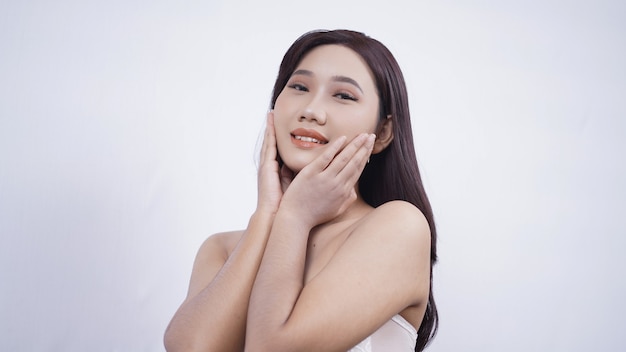 Asian girl with make-up smiling sweetly both hands on cheeks isolated on white background