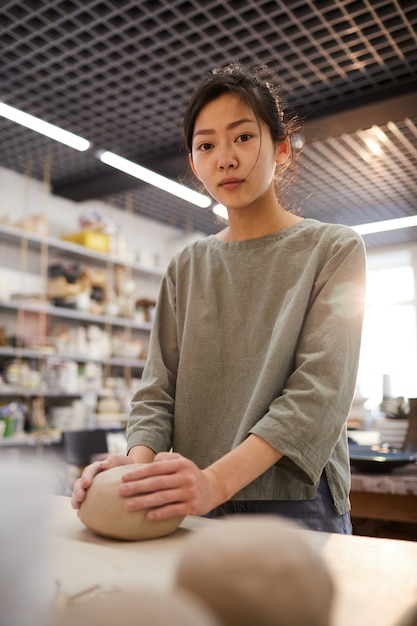 Asian girl working in pottery workshop