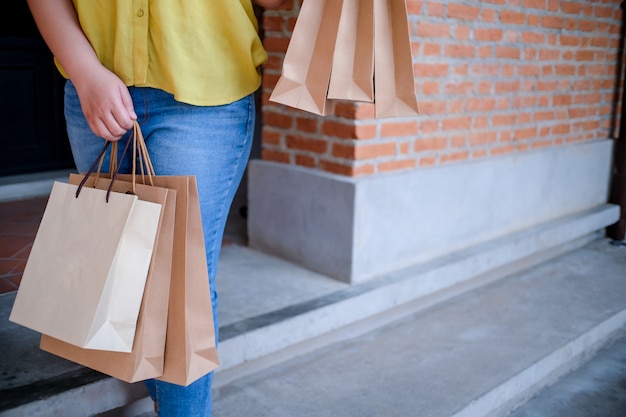 Asian girls holding sale shopping bags. consumerism lifestyle concept in the shopping mall.