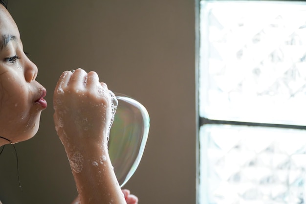 Foto le ragazze asiatiche giocano con le bolle di sapone in bagno