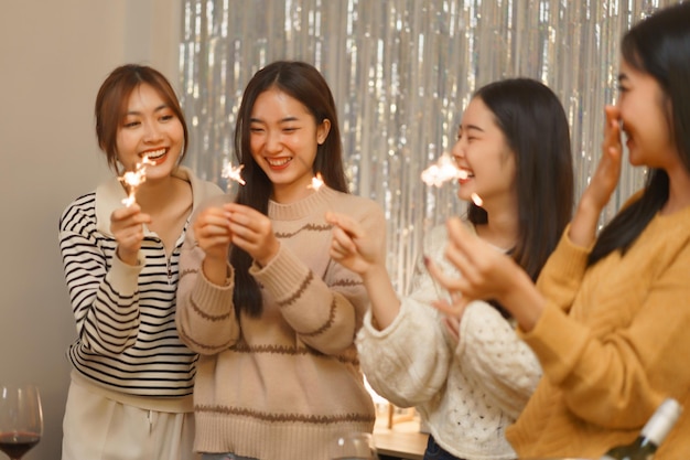 Photo asian girls playing sparklers whil and enjoying some happy moment with her friends birthday