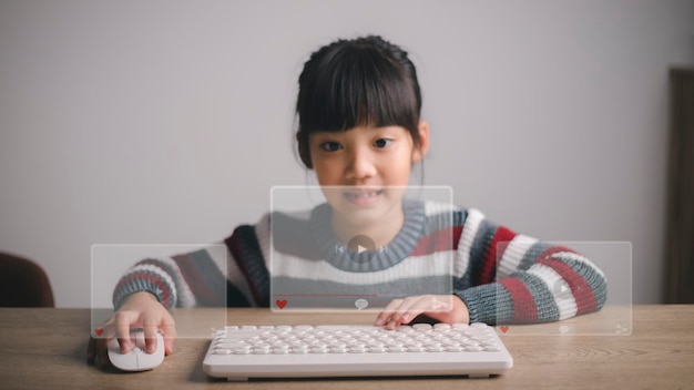 Asian girls use mouse and keyboard for streaming online, watching video on internet, live study, tutorial, online learning, education, home schooling. during Covid-19 pandemic lockdown.
