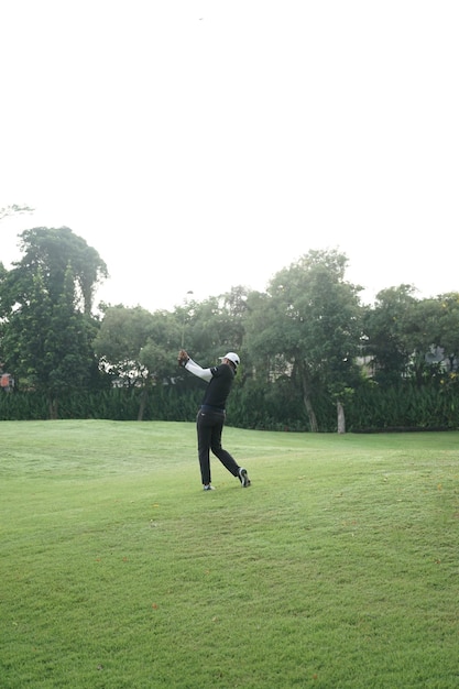 Photo asian golf player on golf course golfer taking a shot