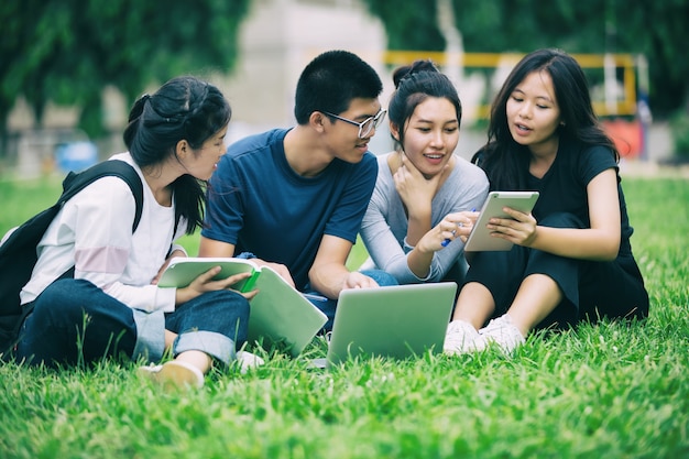 Asian Group of students sharing with the ideas for working on the campus lawn