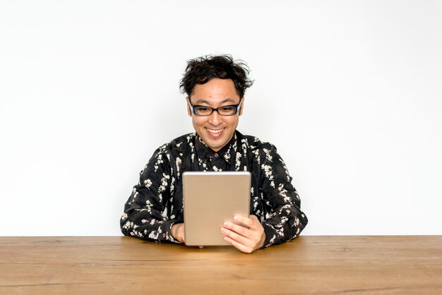 Asian guy with eyeglasses using digital tablet