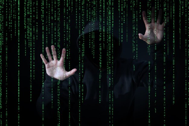 Asian hacker in black hood with matrix background