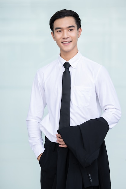 Азиатский красивый деловой человек в белой рубашке улыбается