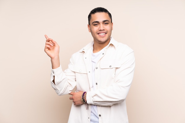 Asian handsome man over isolated background happy and pointing up