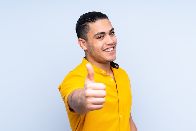 Asian handsome man over isolated background with thumbs up because something good has happened