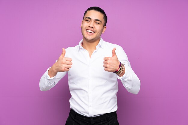 Asian handsome man isolated on blue background giving a thumbs up gesture