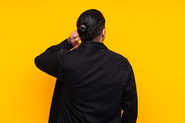 Asian handsome man isolated on yellow background in zen pose