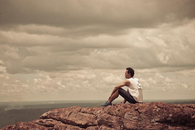 Asian handsome man sit alone on the mountain vintage style