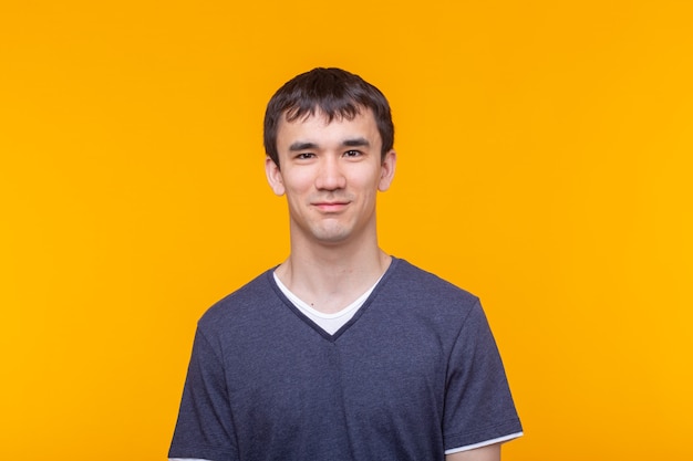 Asian handsome man wearing blue t-shirt on yellow background