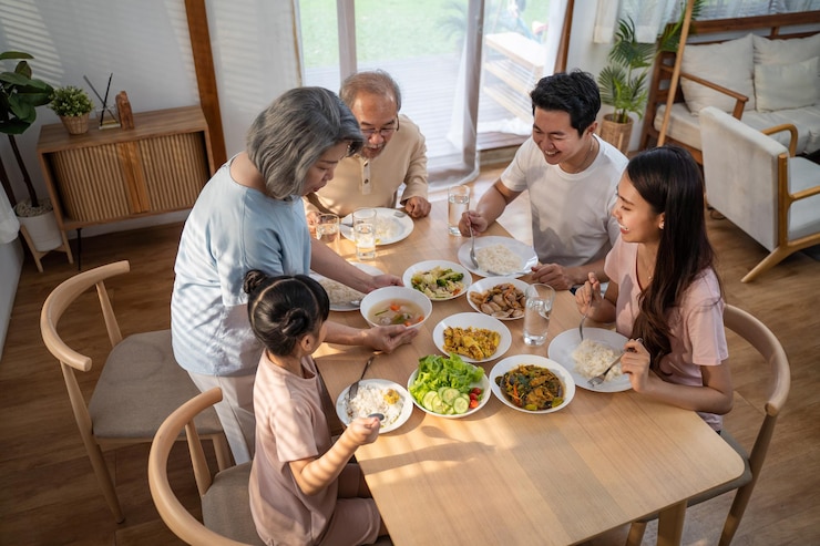 Photo アジアの幸せな家族は家で一緒に夕食のテーブルで昼食を楽しんでいます