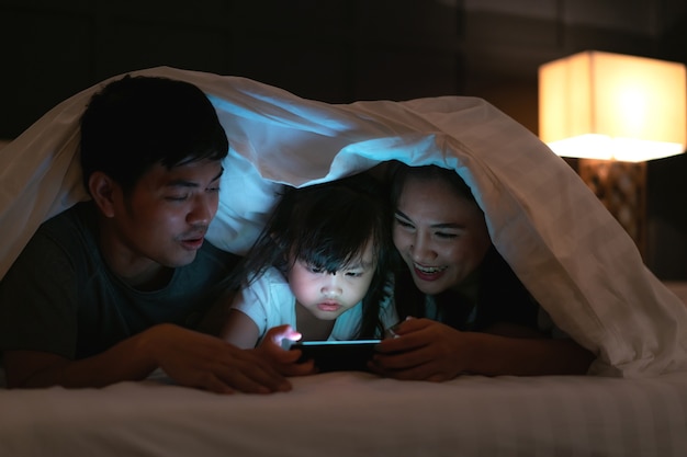 Famiglia felice asiatica che guarda film sullo smartphone