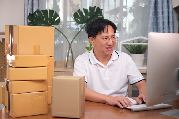 Asian happy smiling business man entrepreneur using computer