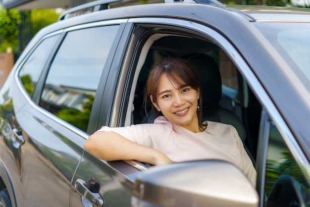 車を運転するアジアの幸せな若い美しい女性