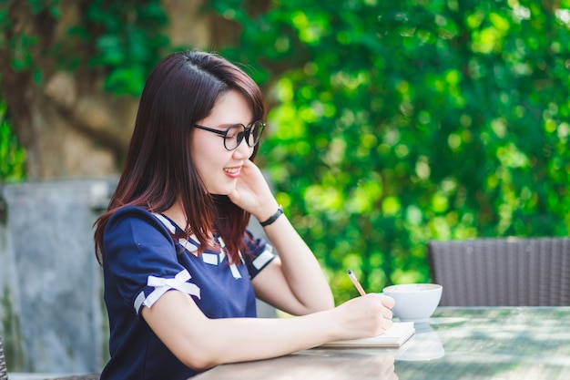 Asian happy young business woman working make a note of something making notes