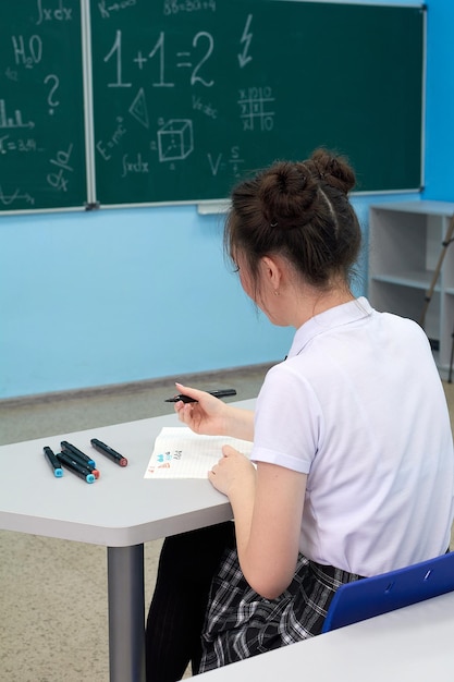 사진 아시아 고등학교 소녀가 블랙보드에서 기하학을 해결합니다.