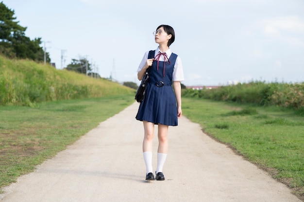 Asian high school girl with glasses looking up at the sky