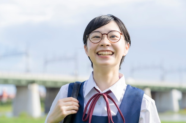 制服を着て学校で笑顔のアジアの女子高生