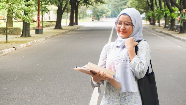 Ragazza asiatica dell'hijab che sta studiando all'università
