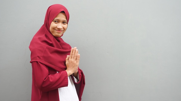 Азиатская женщина в хиджабе извиняется за руку. Рамадан праздновать