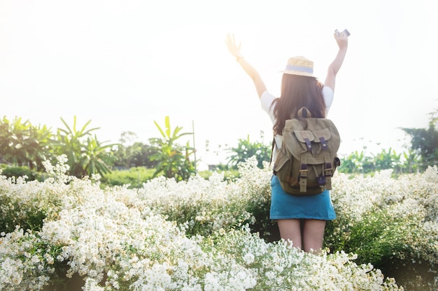 Photo asian hipster cute teen girl with camera in white flower garden, with vintage tone nature concept