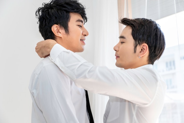 Asian homosexual couple helping each other dress up
