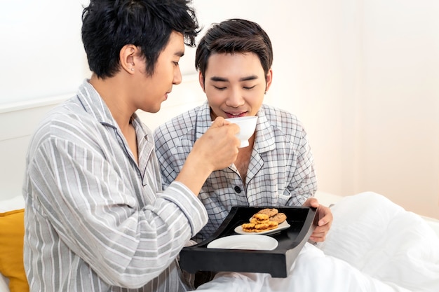잠옷에 아시아 동성애 커플 침대에서 아침 식사