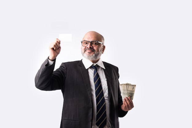 Photo asian indian old businessman holding currency notes, money fan, blank electronic debit credit card