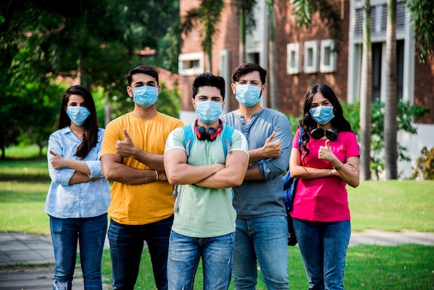 Asian Indian students wears face mask and follow social distancing norms in college or university campus after corona Pandemic unlock, focus on one student