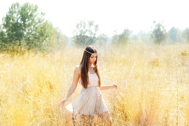 Asian indian woman walking in golden dried field