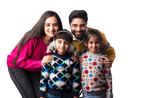 Asian Indian young family wears sweater or warm woolen or woollen winter cloths, standing isolated against white background