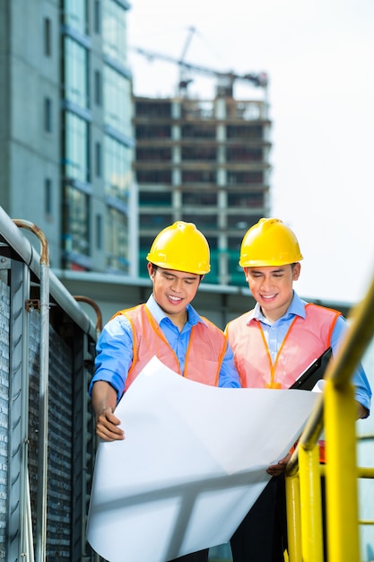 Asian Indonesian construction workers on building site