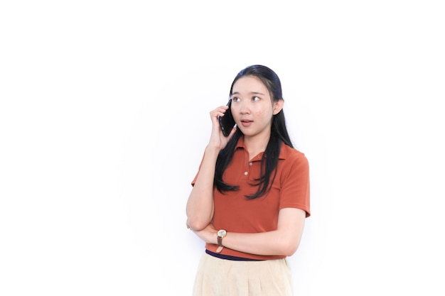オレンジ色のシャツを着てスマートフォンで話すアジア系インドネシア人モデル