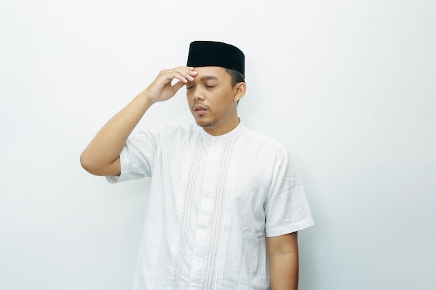 Photo asian indonesian muslim man put his hands on head for headache gesture during fasting ramadan