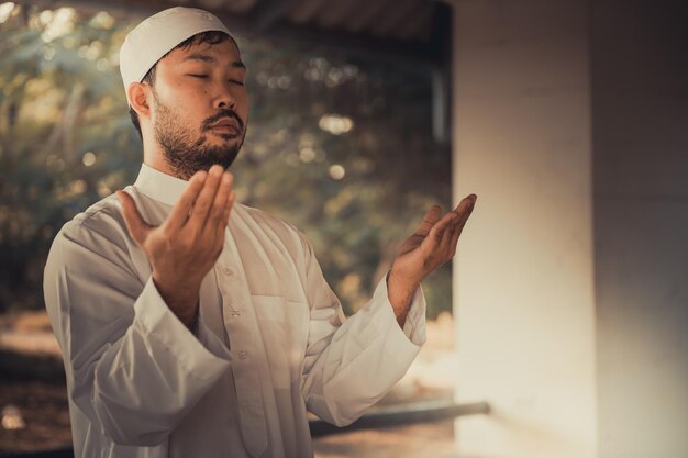 Asian islam man prayerYoung Muslim prayingRamadan festival concept