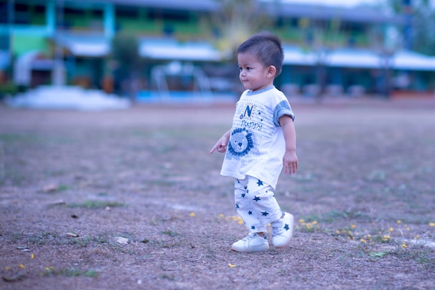 Asian kid boy having fun to play on children's climbing toy at school playground