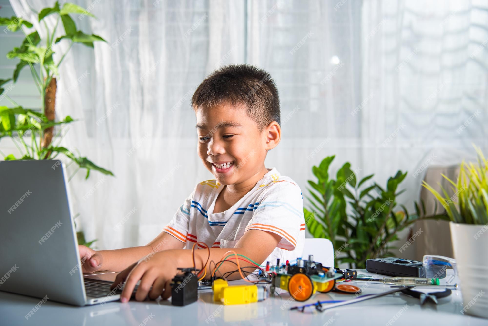 Premium Photo  Asian little boy programming code to robot machine