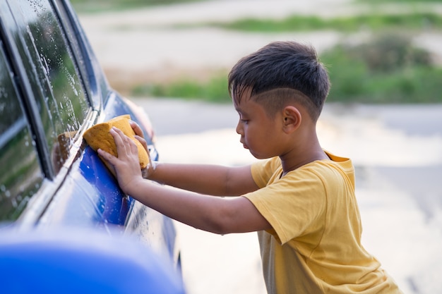 Asian kid boy washing car 