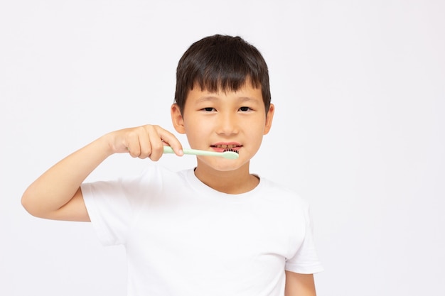 Premium Photo | Asian kid brushing teeth close up.