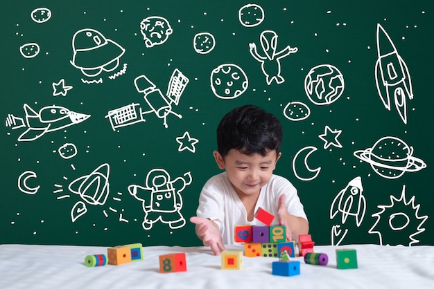 Bambino asiatico che impara giocando con la sua immaginazione sulla scienza e l'avventura spaziale