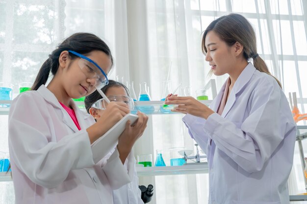 실험실에서 과학자와 함께 배우는 아시아 아이. 신체검사 및 과학교육 수업.