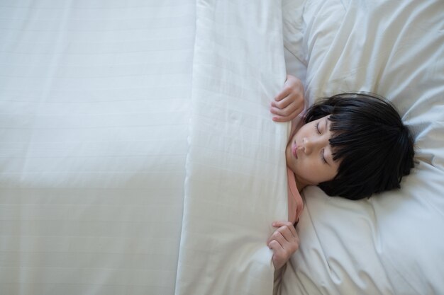 asian kid sleep on bed, sick child