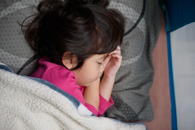 asian kid sleep on bed sick child